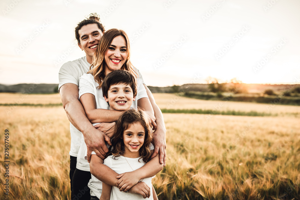 Portrait of a happy young family smiling in the countryside. Concept of family fun in nature. Portrait of a happy young family smiling in the countryside. Concept of family fun in nature.