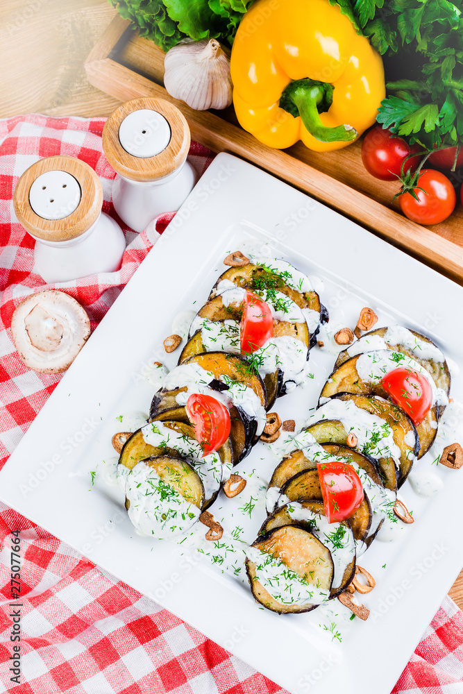 Grilled slices of eggplant and tomatoes in stack with spicy sauce Grilled slices of eggplant and tomatoes in stack with spicy sauce