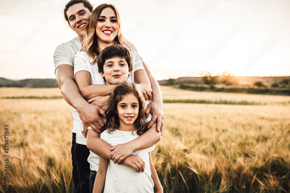 Portrait of a happy young family smiling in the countryside. Concept of family fun in nature.