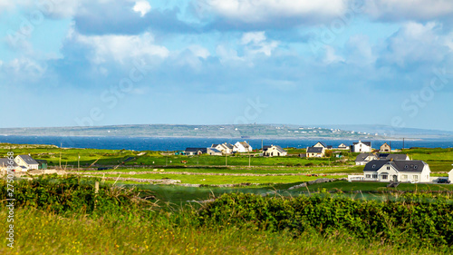 Beautiful meadow, farms and the sea in the background near the village of Doolin, Wild Atlantic Way, beautiful sunny spring day in County Clare in Ireland