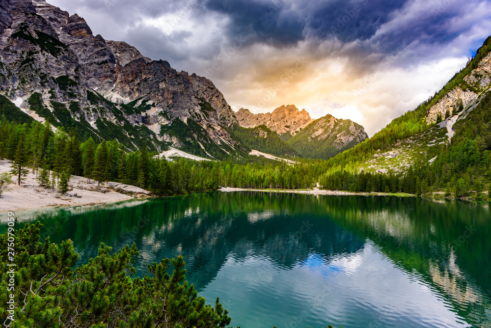 Lake Braies also known as Pragser Wildsee  in beautiful mountain landscape. Sun and cloud scenery at sunset time. Amazing Travel destination Lago di Braies in Dolomites, South Tyrol, Italy, Europe.
