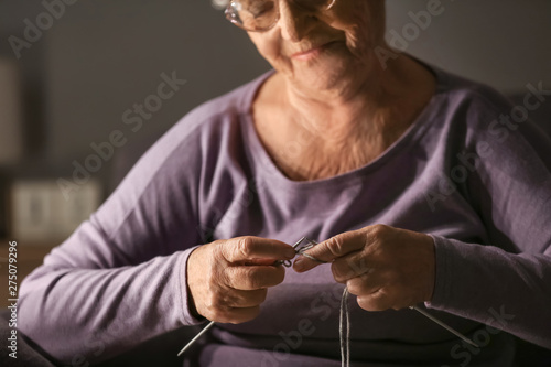 Senior woman knitting at ho...