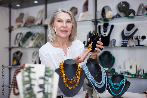 Woman trying on a aventurine necklace and earrings at a jewelry store