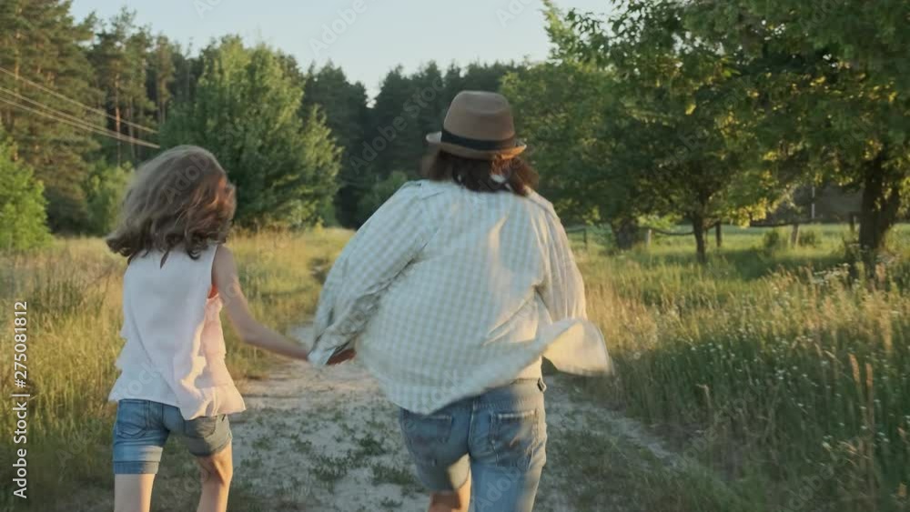 Mother and daughter running holding hands, back view Mother and daughter running holding hands, back view