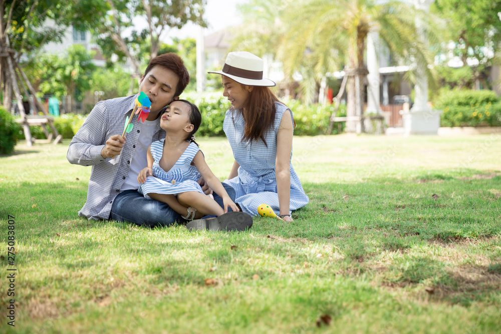 Happy Asian family. Father, mother and daughter in a park at natural sunlight background. Family vacation concept. Happy Asian family. Father, mother and daughter in a park at natural sunlight background. Family vacation concept.