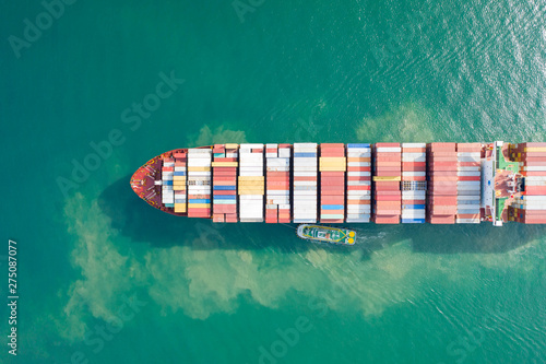Aerial view and top view. Container ship in pier with crane bridge carries out export  and import business in the open sea. Logistics and transportation