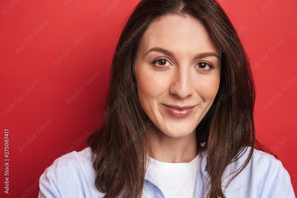 Happy young beautiful woman posing isolated over red wall background. Happy young beautiful woman posing isolated over red wall background.
