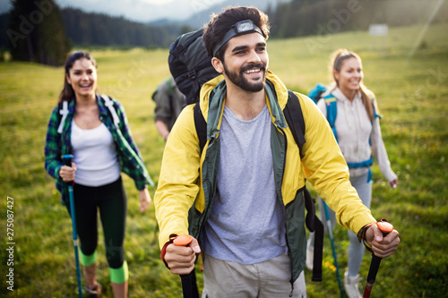 Group of friends on a mountain. Men and women climbing rocks.