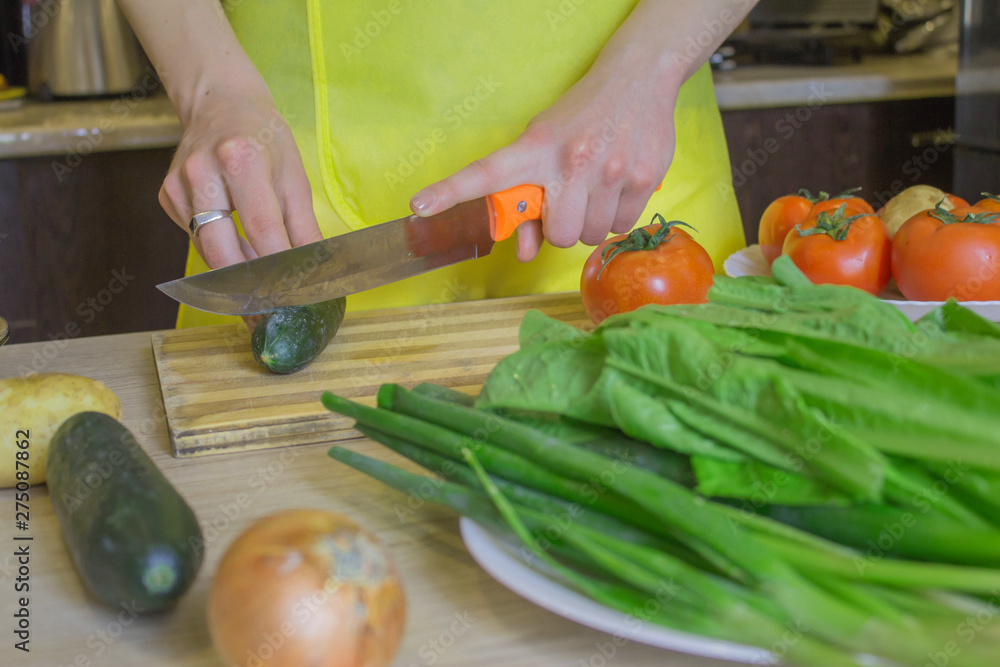 Woman hands cooking healthy meal in the kitchen, behind fresh vegetables. Cropped image of young girl cutting vegetables for Food Woman hands cooking healthy meal in the kitchen, behind fresh vegetables. Cropped image of young girl cutting vegetables for Food