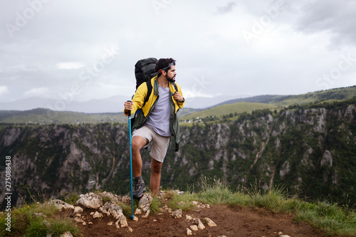 Young man traveling with backpack hiking in mountains