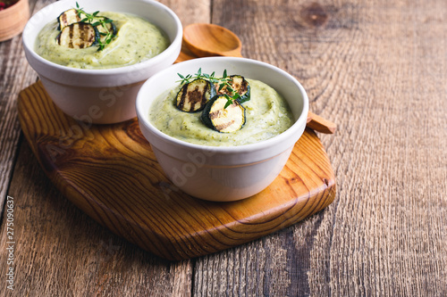 Healthy zucchini cream soup in ceramic bowls