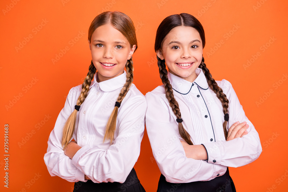 Close-up portrait of two person nice-looking attractive charming cute lovely cheerful content pre-teen girls folded arms isolated over bright vivid shine orange background Close-up portrait of two person nice-looking attractive charming cute lovely cheerful content pre-teen girls folded arms isolated over bright vivid shine orange background