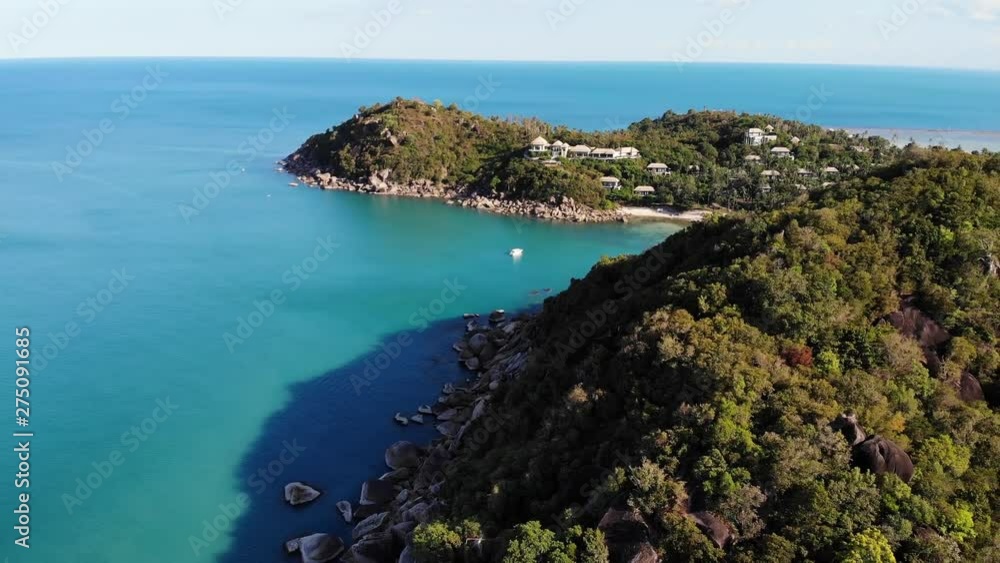 Calm sea near tropical volcanic island. Drone view of peaceful water of blue sea near stony shore and green jungle of volcanic Koh Samui Island on sunny day in Thailand. Silver Beach Calm sea near tropical volcanic island. Drone view of peaceful water of blue sea near stony shore and green jungle of volcanic Koh Samui Island on sunny day in Thailand. Silver Beach