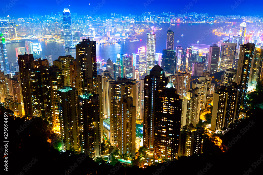Fototapeta premium The most famous view of Hong Kong at twilight sunset. Hong Kong skyscrapers skyline cityscape view from Victoria Peak illuminated in the evening. Hong Kong, special administrative region in China.