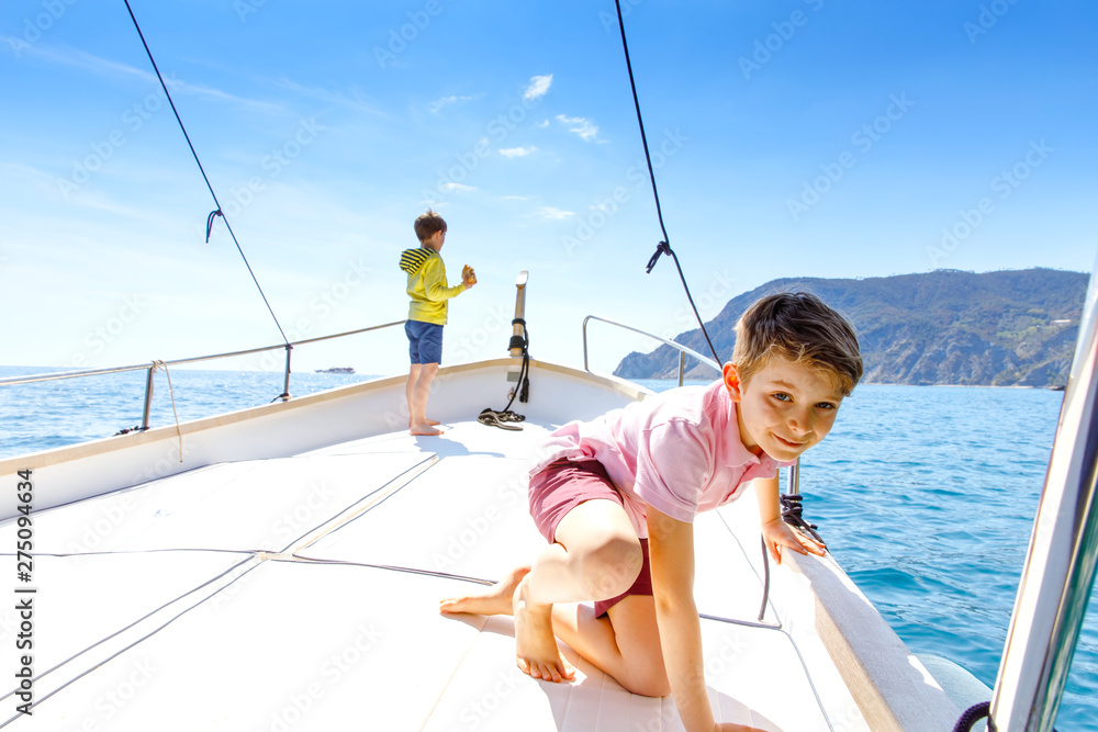 Two little kid boys, best friends enjoying sailing boat trip. Family vacations on ocean or sea on sunny day. Children smiling. Brothers, schoolchilden, siblings, best friends having fun on yacht. Two little kid boys, best friends enjoying sailing boat trip. Family vacations on ocean or sea on sunny day. Children smiling. Brothers, schoolchilden, siblings, best friends having fun on yacht.