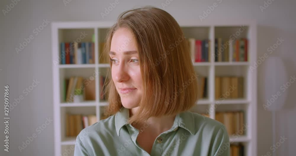 Portrait of caucasian young female student smiles joyfully and dreamily into camera at home. Portrait of caucasian young female student smiles joyfully and dreamily into camera at home.