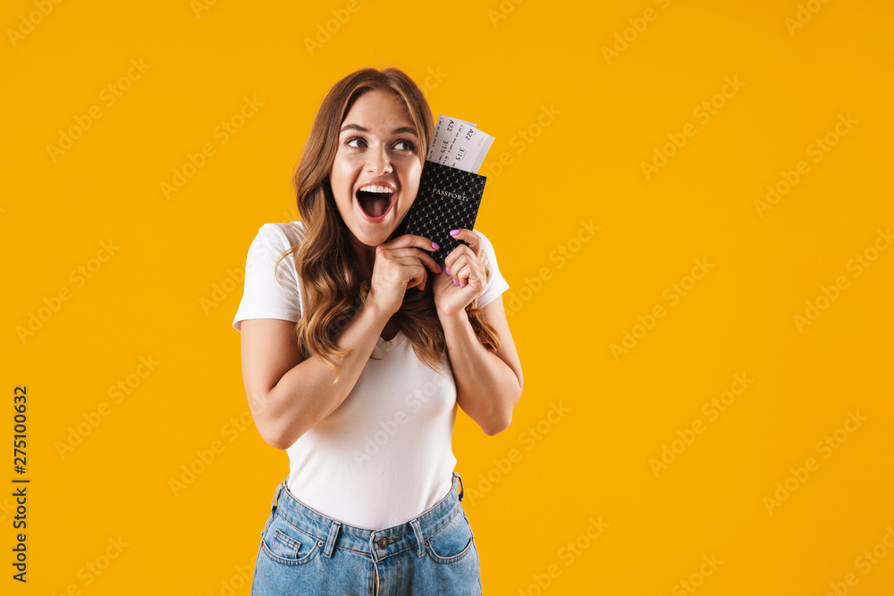 Obraz premium Photo of brunette young woman rejoicing while holding passport and travel tickets