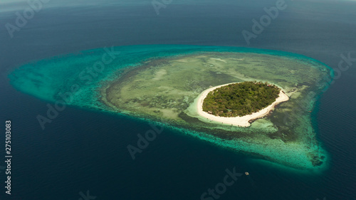 Tropical island and sandy beach surrounded by atoll coral reef and blue sea, aerial view. Small island with sandy beach. Summer and travel vacation concept, Mantigue Philippines Mindanao