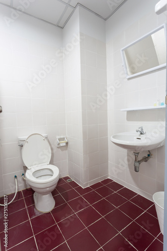 White toilet with red floor textile