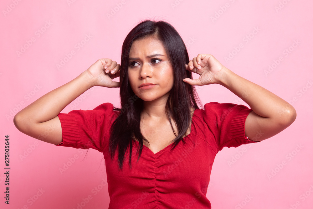 Young Asian woman block both ears with fingers. Young Asian woman block both ears with fingers.