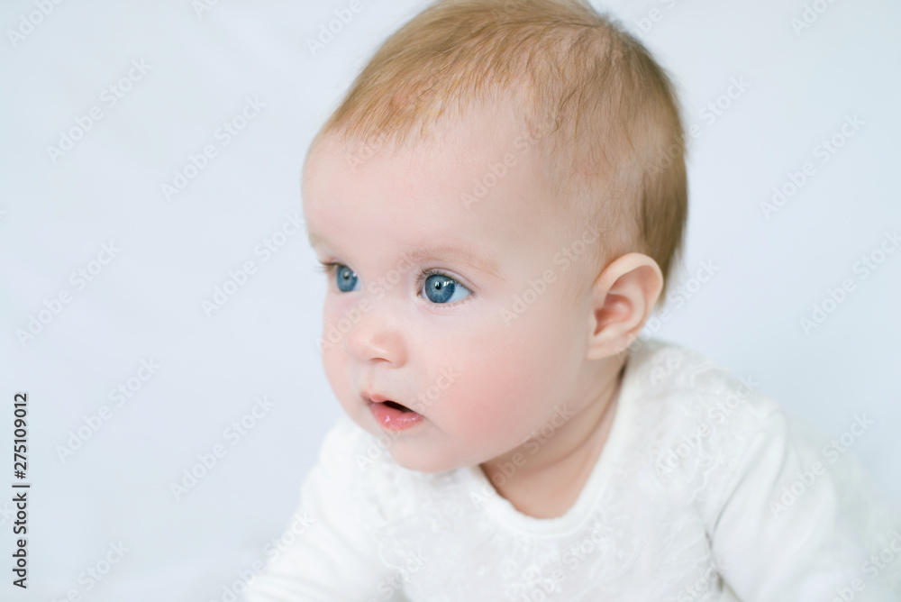 large portrait of little girl with blue eyes in white dress on white background, little girl looking at camera