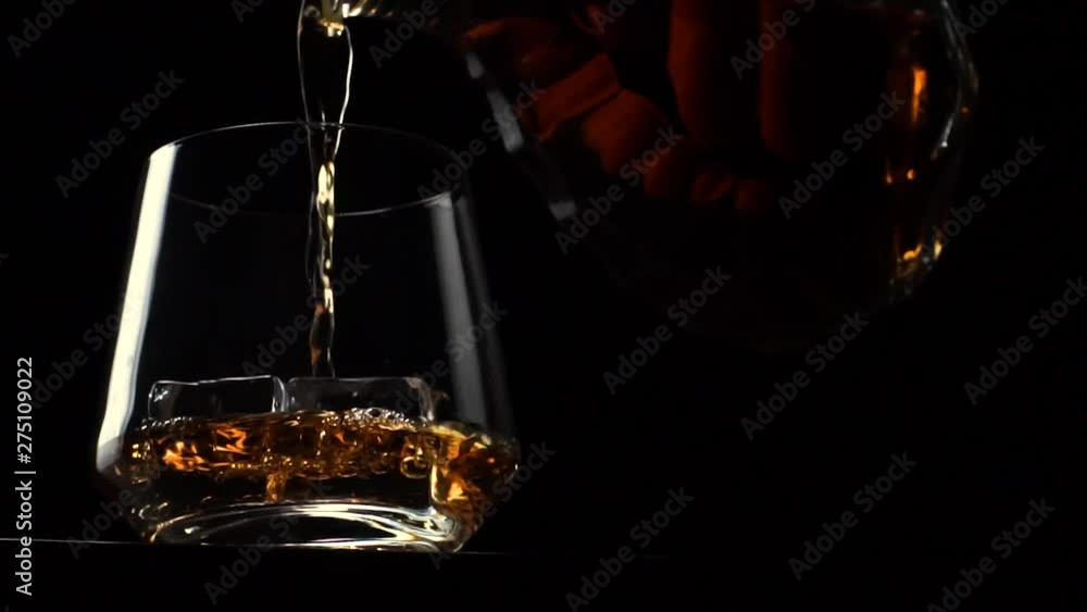 Hand Pours Alcoholic Beverage Whiskey Or Bourbon Into A Glass Hand Pours Alcoholic Beverage Whiskey Or Bourbon Into A Glass
