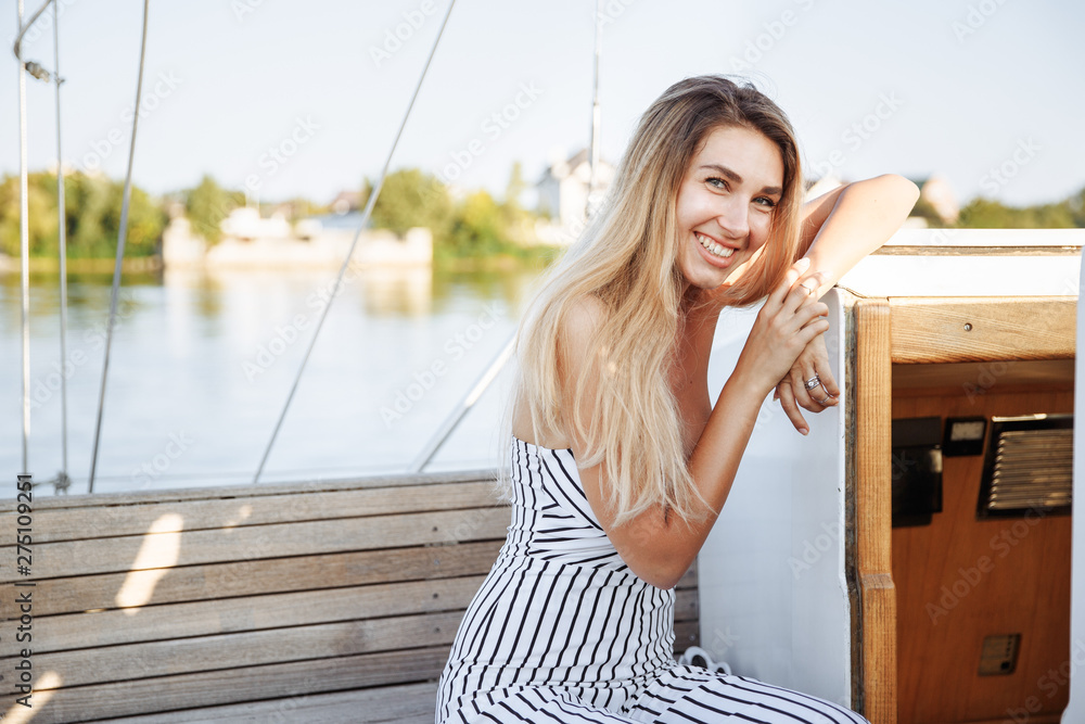 woman resting on a yacht in a striped pantsuit woman resting on a yacht in a striped pantsuit