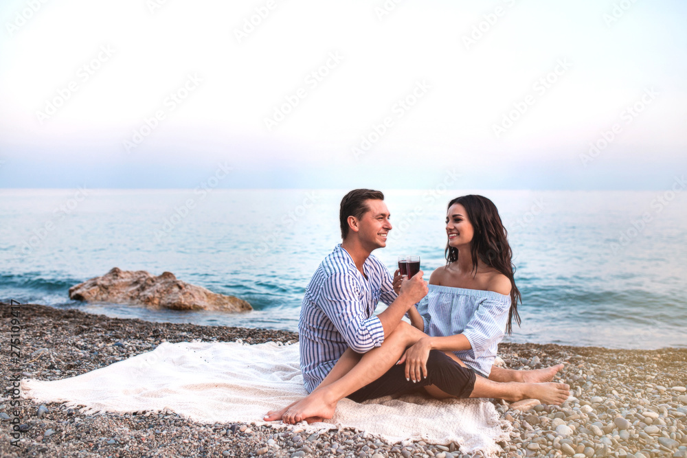 Romantic couple sitting with wineglasses at seaside at sunset. Romantic couple sitting with wineglasses at seaside at sunset.
