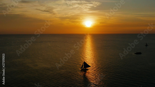 Colorful sunset above the sea surface with sailing yachts, aerial view Boracay, Philippines. Reflected sun on a water surface. Sunset over ocean. Seascape, Summer and travel vacation concept