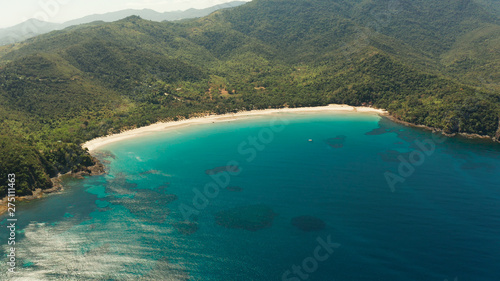 Aerial view beautiful tropical beach Nagtabon in the cove with blue lagoon and turquoise water surrounded by rainforest. Palawan, Philippines. tropical landscape. Seascape island and clear blue water