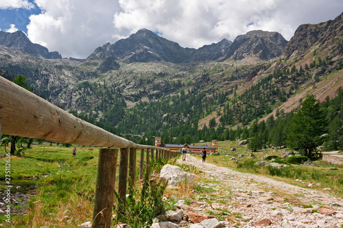 Some hikers travel through the Valasco alpine valley on a summer day. photo