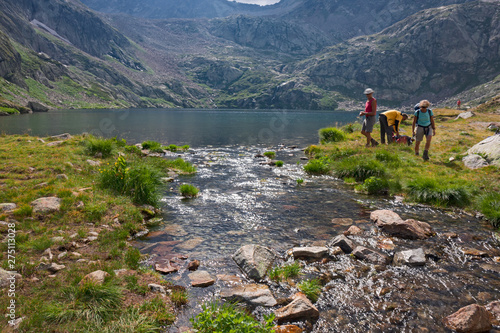 Some hikers near the Inferiore di Valscura lake at an altitude of 2265 meters. photo