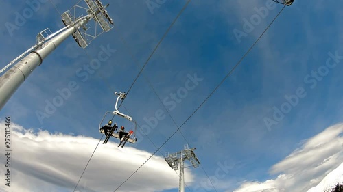 People are lifting on ski-lift in the mountains, view from bellow, slow motion photo