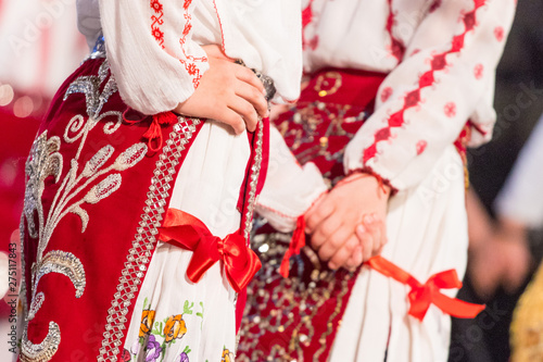 Close up on hands of young Romanian dancers perform a folk dance in traditional folkloric costume. Folklore of Romania