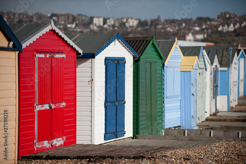 A row of coloured British holiday huts lead into the blurred distance. United Kingdom - Image