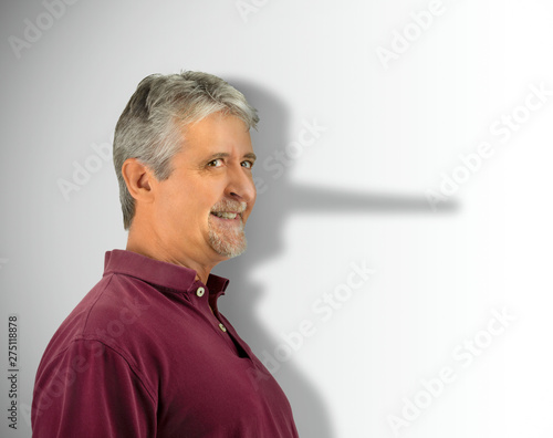 Fotografie Lying dishonest man with his growing long liar Pinocchio nose showing in his sha