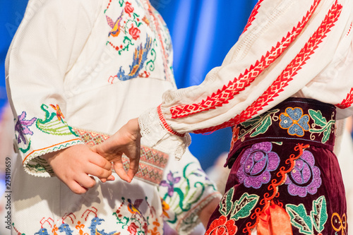 Obraz na płótnie Close up of hands of young Romanian dancers perform a folk dance in traditional folkloric costume