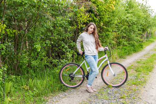Young woman riding bicycle in summer city park outdoors. Active people. Hipster girl relax and rider bike. Cycling to work at summer day. Bicycle and ecology lifestyle concept © Юлия Завалишина
