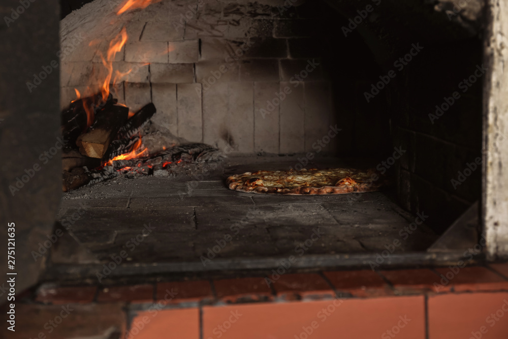 Burning firewood and tasty pizza in oven at restaurant kitchen Burning firewood and tasty pizza in oven at restaurant kitchen