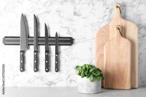 Obraz na płótnie Magnetic holder with set of knives on marble wall in kitchen