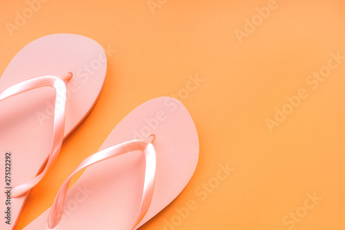 Living coral flip flops on a coral background. Color of the year 2019. Place for text.