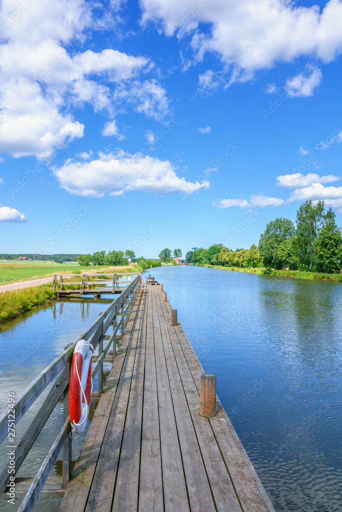 Wooden jetty at a canal with lifebuoys Wooden jetty at a canal with lifebuoys