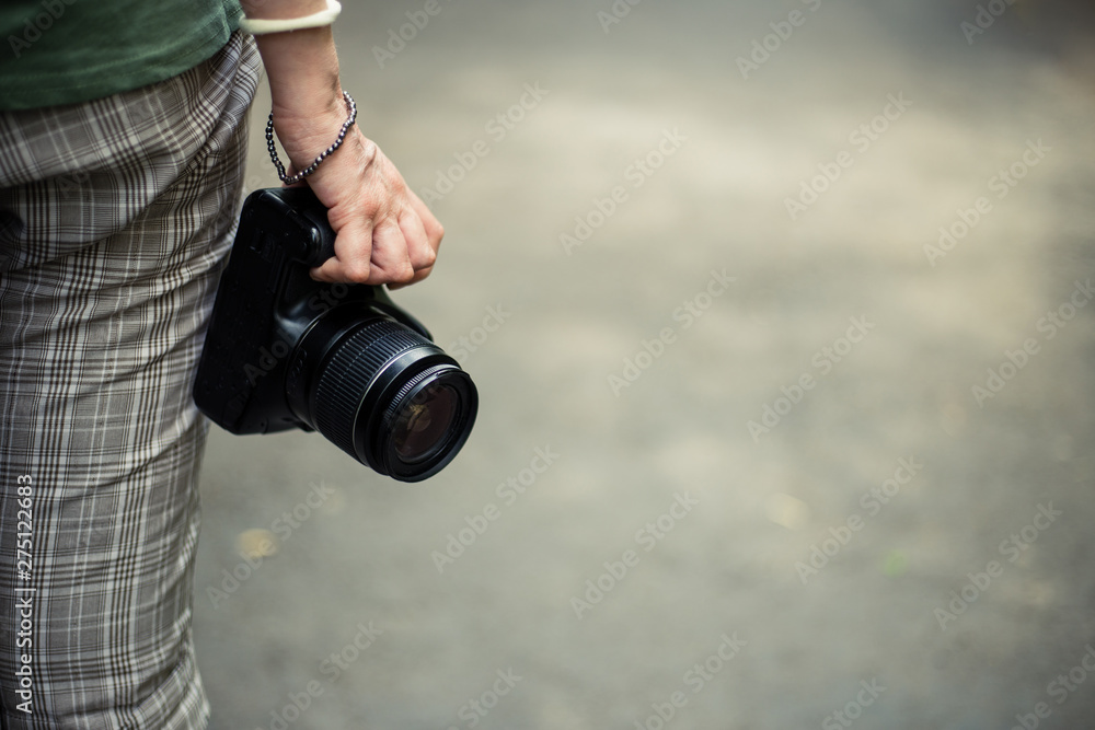 Fototapeta premium Small video camera held by young woman hand with copy space – Casually dressed girl with modern recording equipment – Professional device for photo shooting