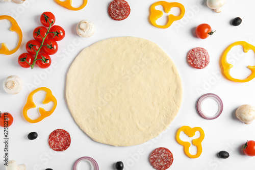 Flat lay composition with base and ingredients for pizza on white background