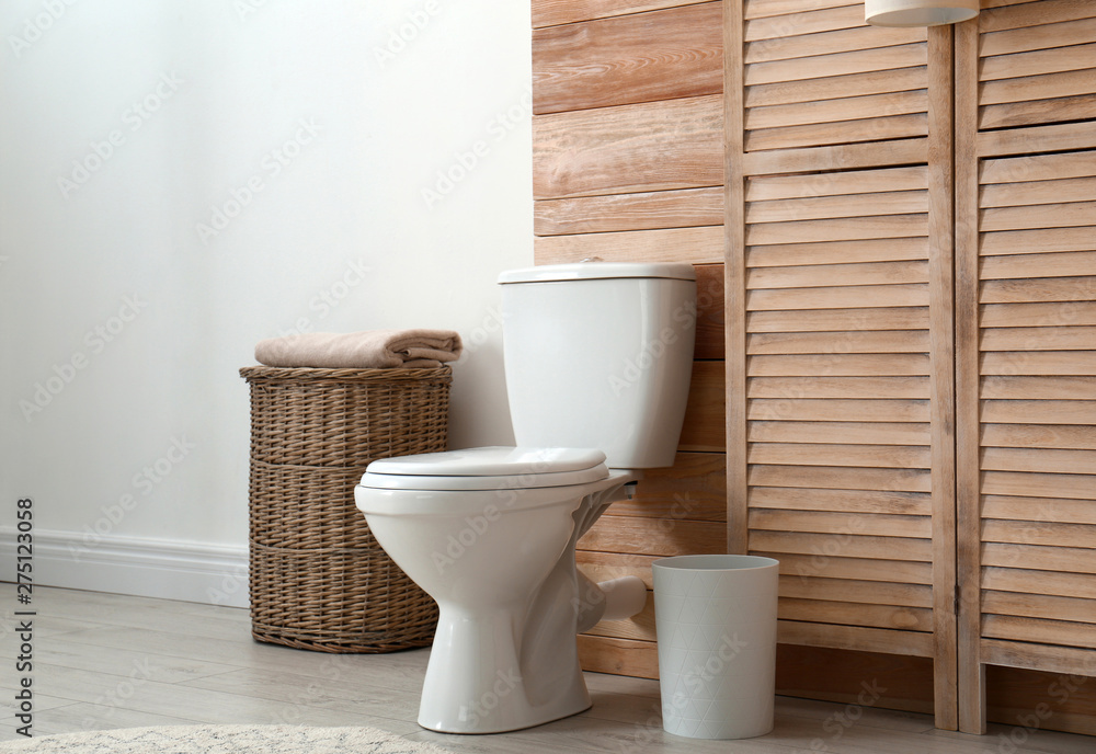 Toilet bowl near wooden wall in modern bathroom interior Toilet bowl near wooden wall in modern bathroom interior