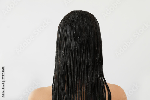 Woman with mask on her long hair in light bathroom