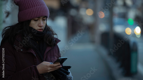 Woman use smart phone on street city in winter