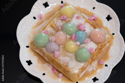 Bua Loi Thai dessert with colorful ball flour and coconut milk topped on waffle.