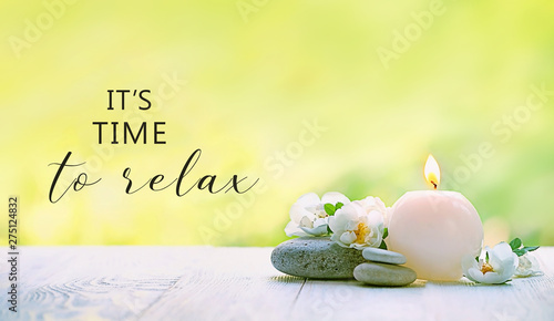 it’s time to relax. beautiful scene with candle, flowers and stones. romantic still life. Relax still life with zen pebble stones, candle. spa wellness scene, soul equanimity calmnes concept