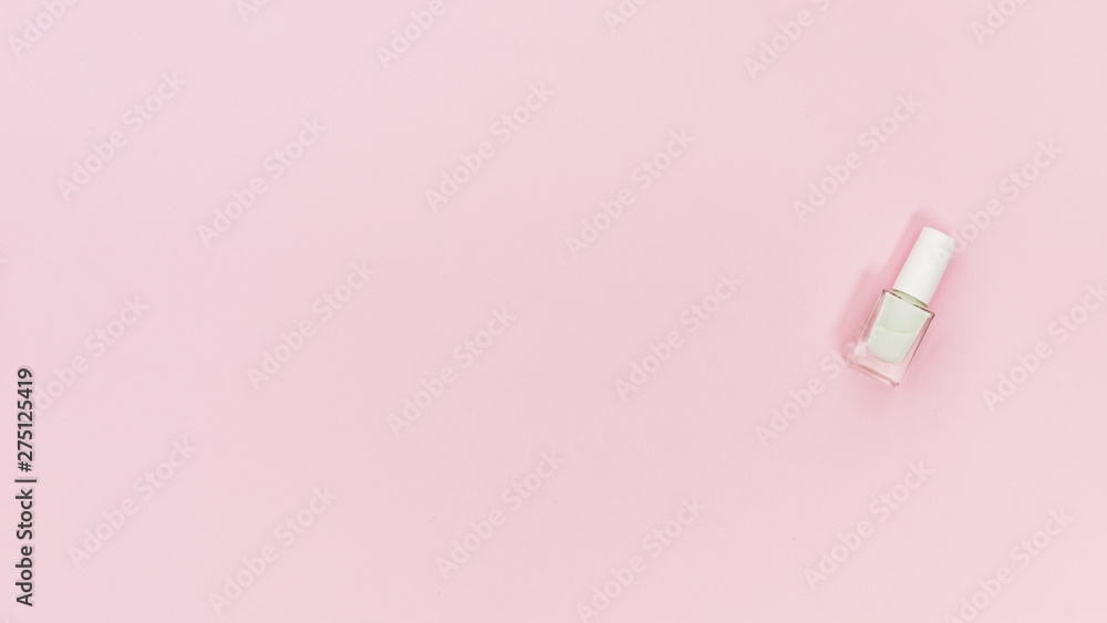 White bottle of nail polish on pink background with copy space for writing the text White bottle of nail polish on pink background with copy space for writing the text